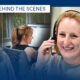 Team members wearing headsets work at computers in an office; a smiling woman in the foreground wears a headset.