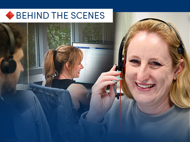 Team members wearing headsets work at computers in an office; a smiling woman in the foreground wears a headset.