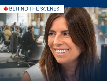 A photo of Vic Sharples, CHL Mortgages Head of Secured Lending smiling, with lending team at work in the background.