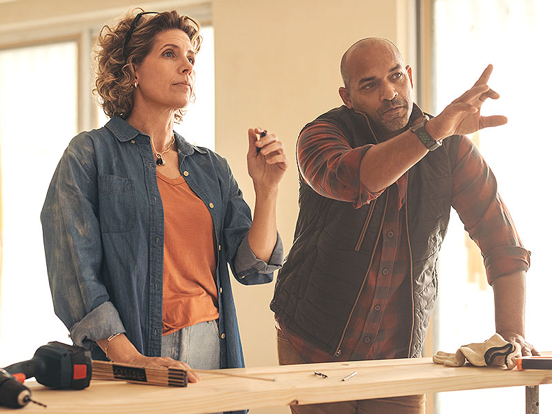 A professional landlord and contractor discuss a refurb over a workbench